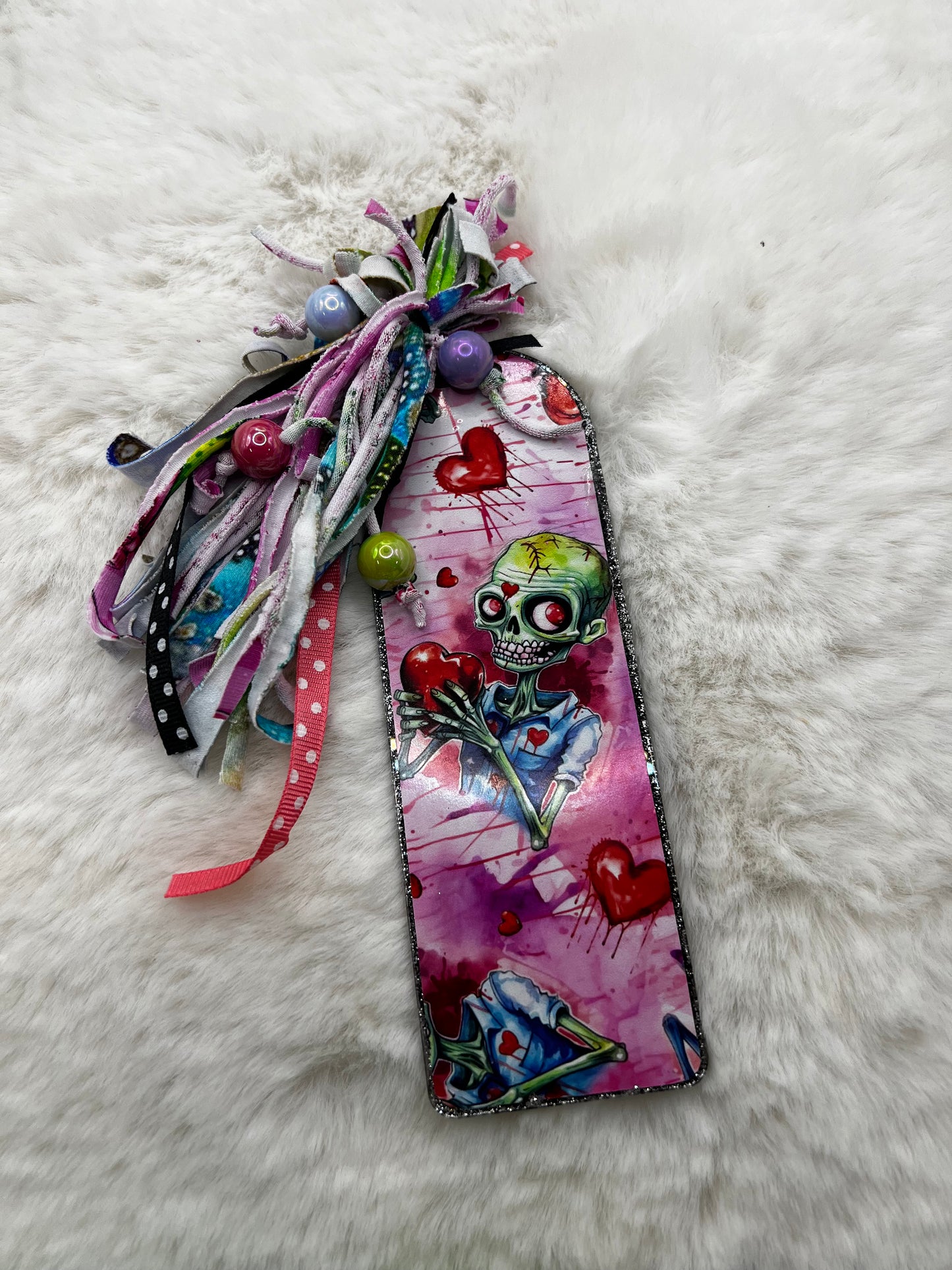 Decorative bookmark with colorful zombie design on a white fluffy surface