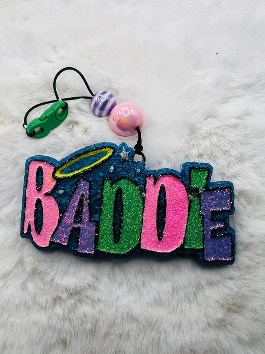 Colorful freshie with 'BADDIE' text on a fluffy white surface