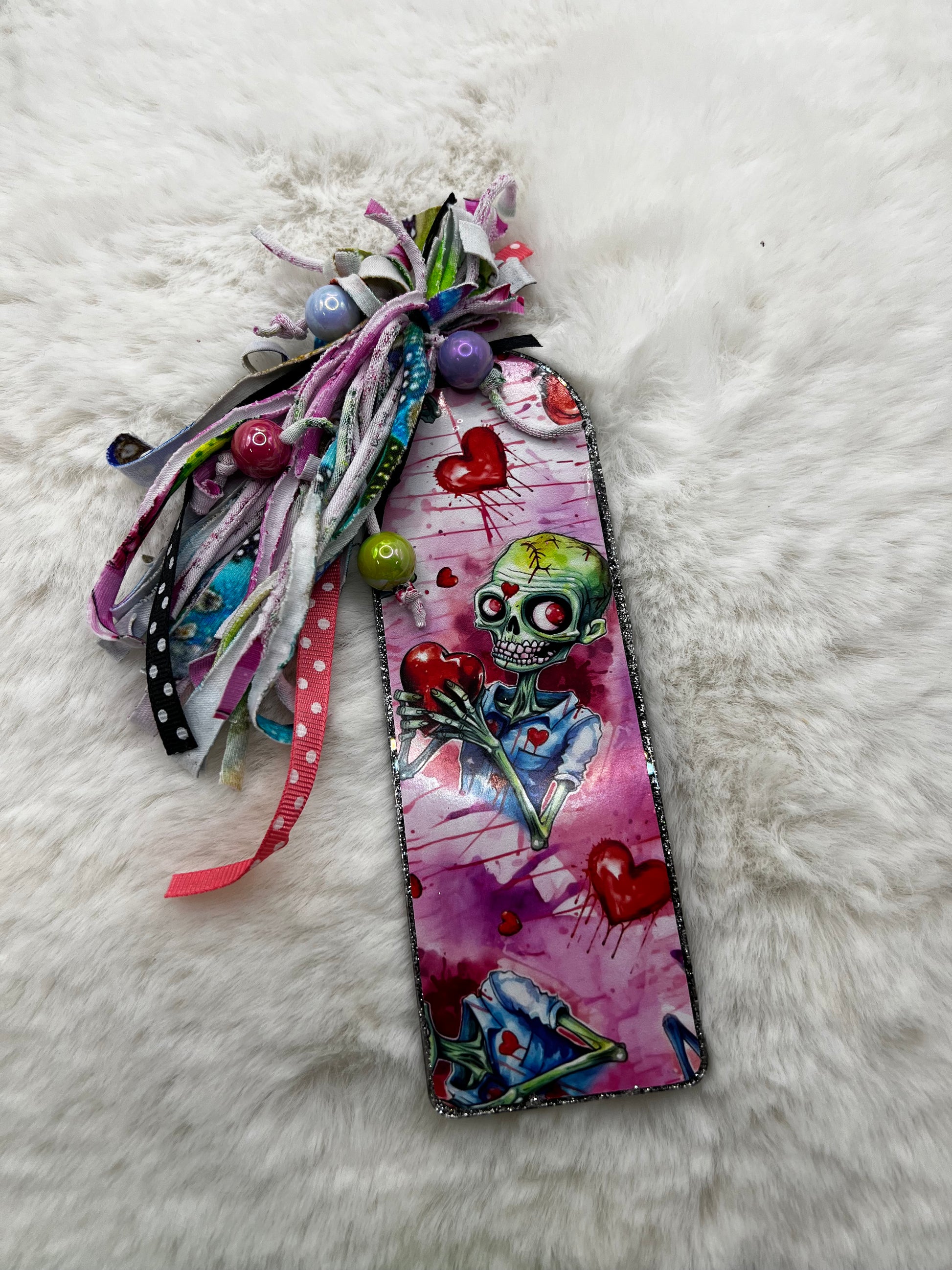 Decorative bookmark with colorful zombie design on a white fluffy surface