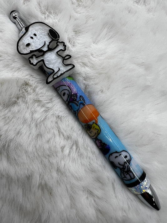 Pen with Snoopy cartoon character design on a fluffy white surface