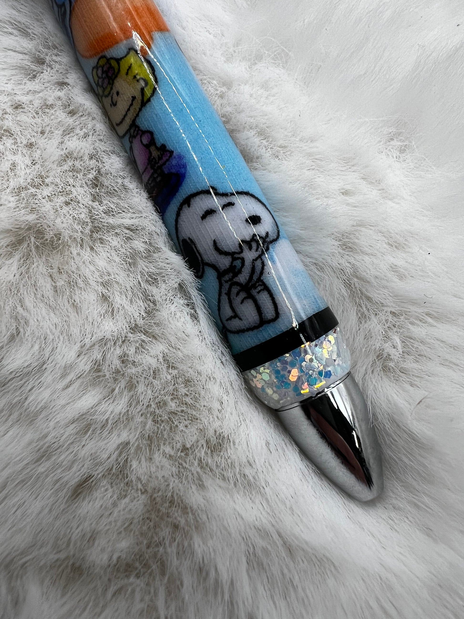Pen with Snoopy design on a fluffy white surface
