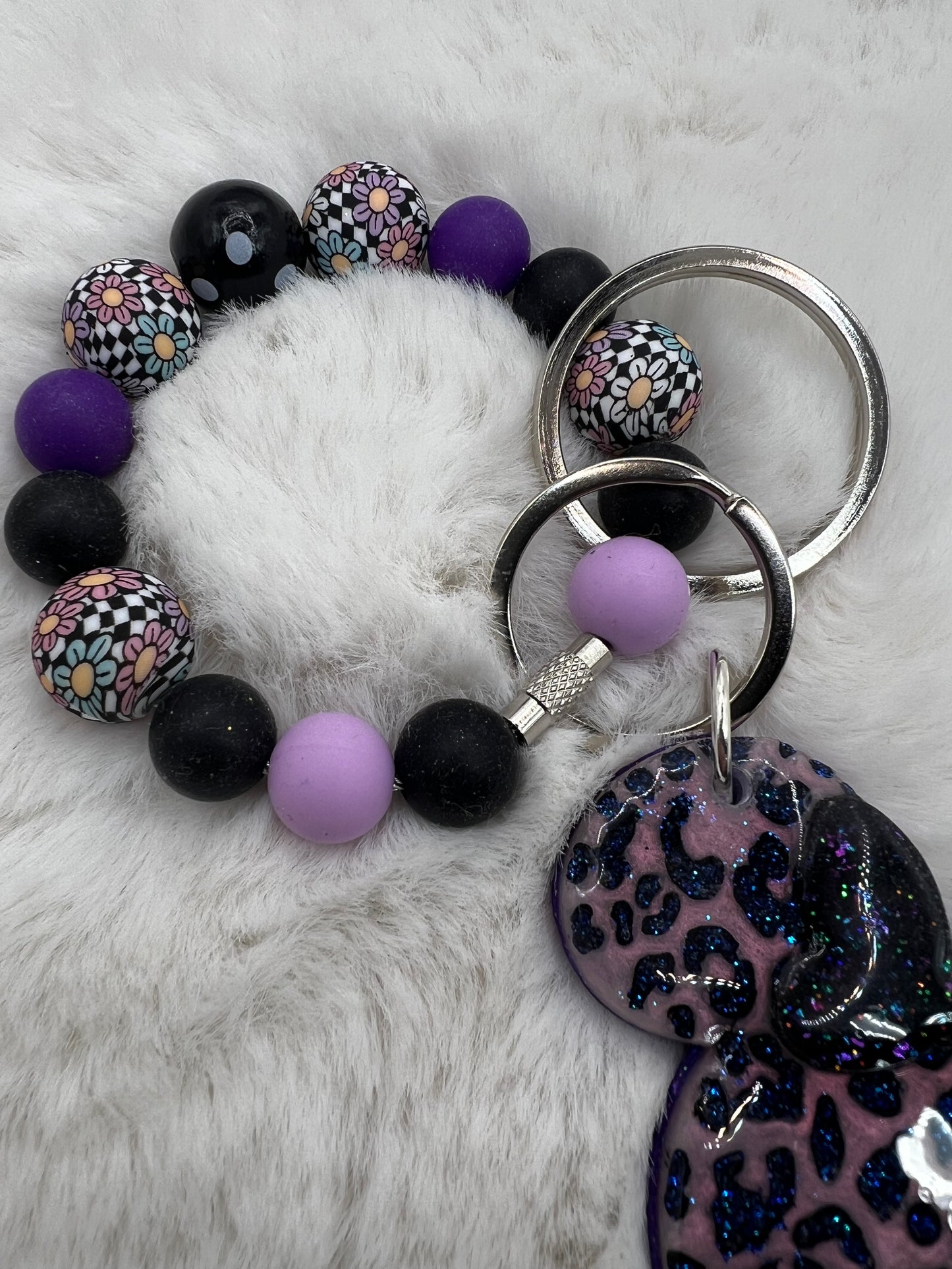 Keychain with colorful beads and a leopard print Minnie Mouse charm on a white fluffy surface