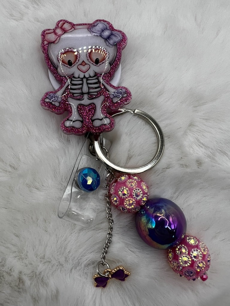Keychain with skeleton design and colorful beads on a fluffy white background