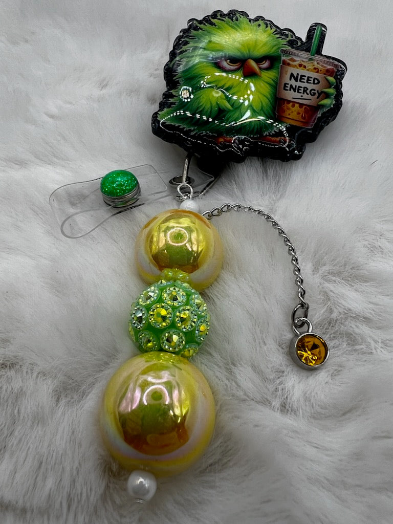 Decorative badge reel with colorful beads and a grumpy bird with a coffee on a fluffy white surface