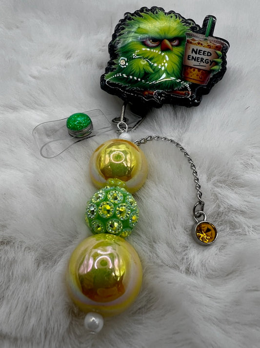 Decorative badge reel with colorful beads and a grumpy bird with a coffee on a fluffy white surface