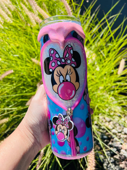 Sparkly pink and purple Minnie Mouse themed tumbler held in front of a grassy background