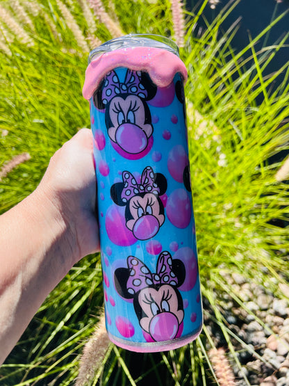 Sparkly pink and purple Minnie Mouse themed tumbler held in front of a grassy background