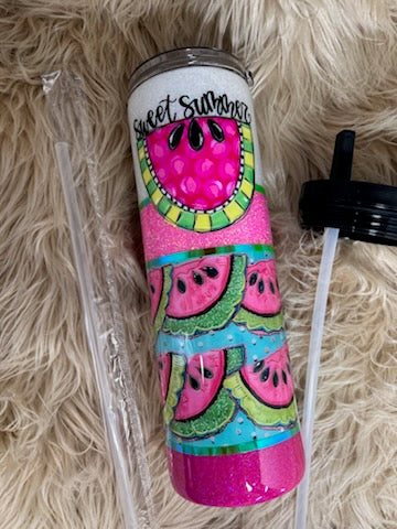 Colorful tumbler with watermelon design on a fluffy beige surface