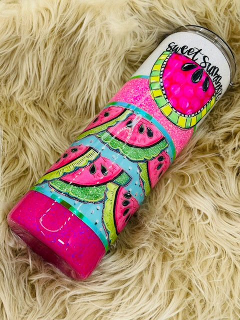 Colorful watermelon-themed tumbler on a fluffy beige surface