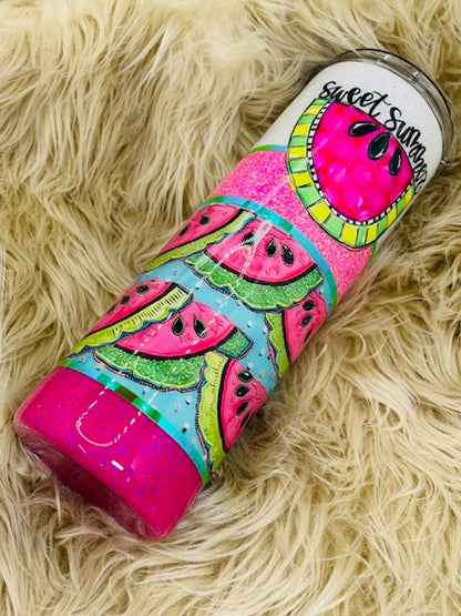 Colorful watermelon-themed tumbler on a fluffy beige surface