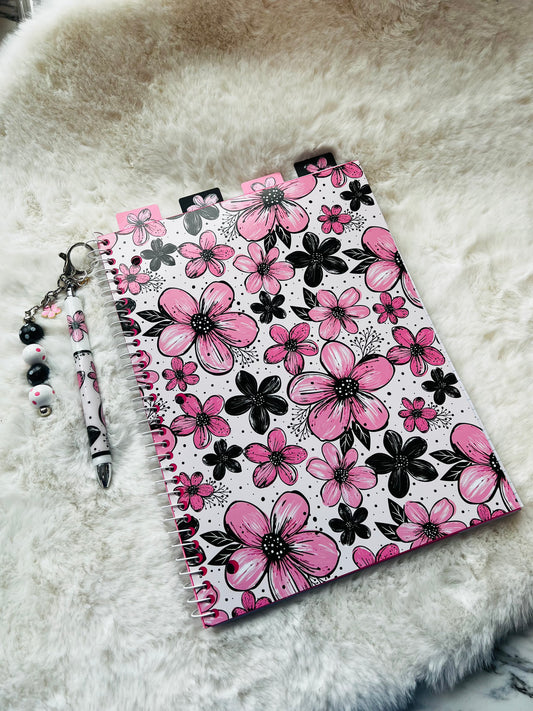 Notebook with pink floral design on a fluffy white surface