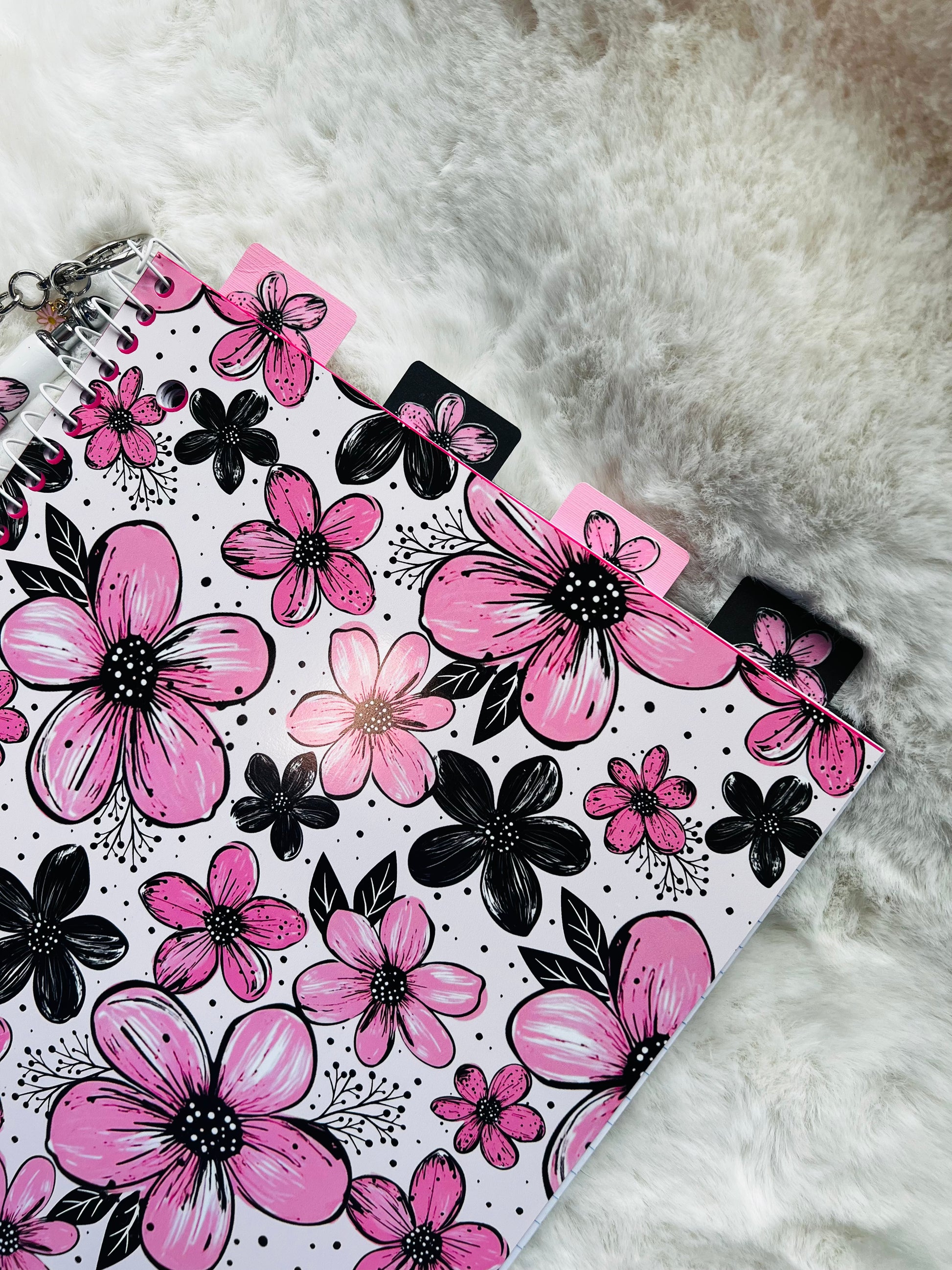 Floral notebook with pink and black flowers on a textured surface