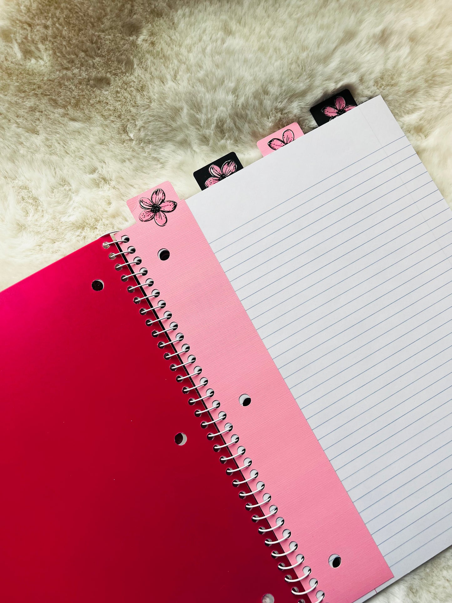 Red notebook with a pink interior page on a textured surface