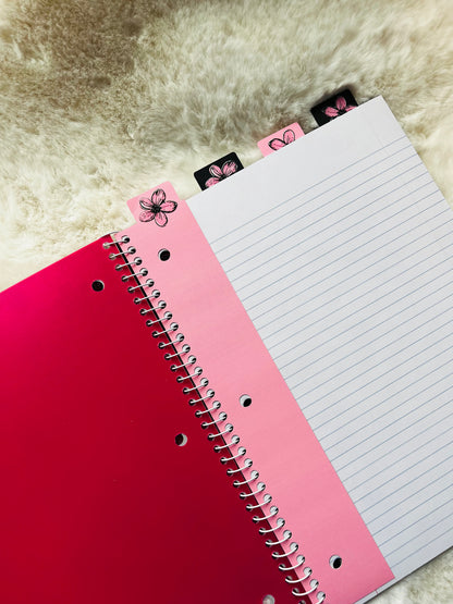 Red notebook with a pink interior page on a textured surface