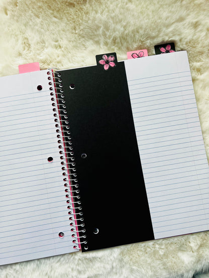 Notebook with a black divider page on a textured surface
