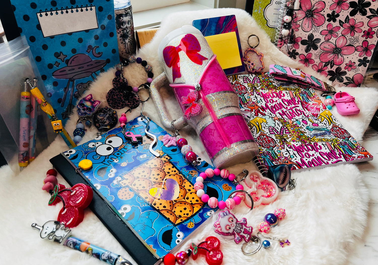 Colorful stationery items including notebooks, pens, and keychains on a white surface.