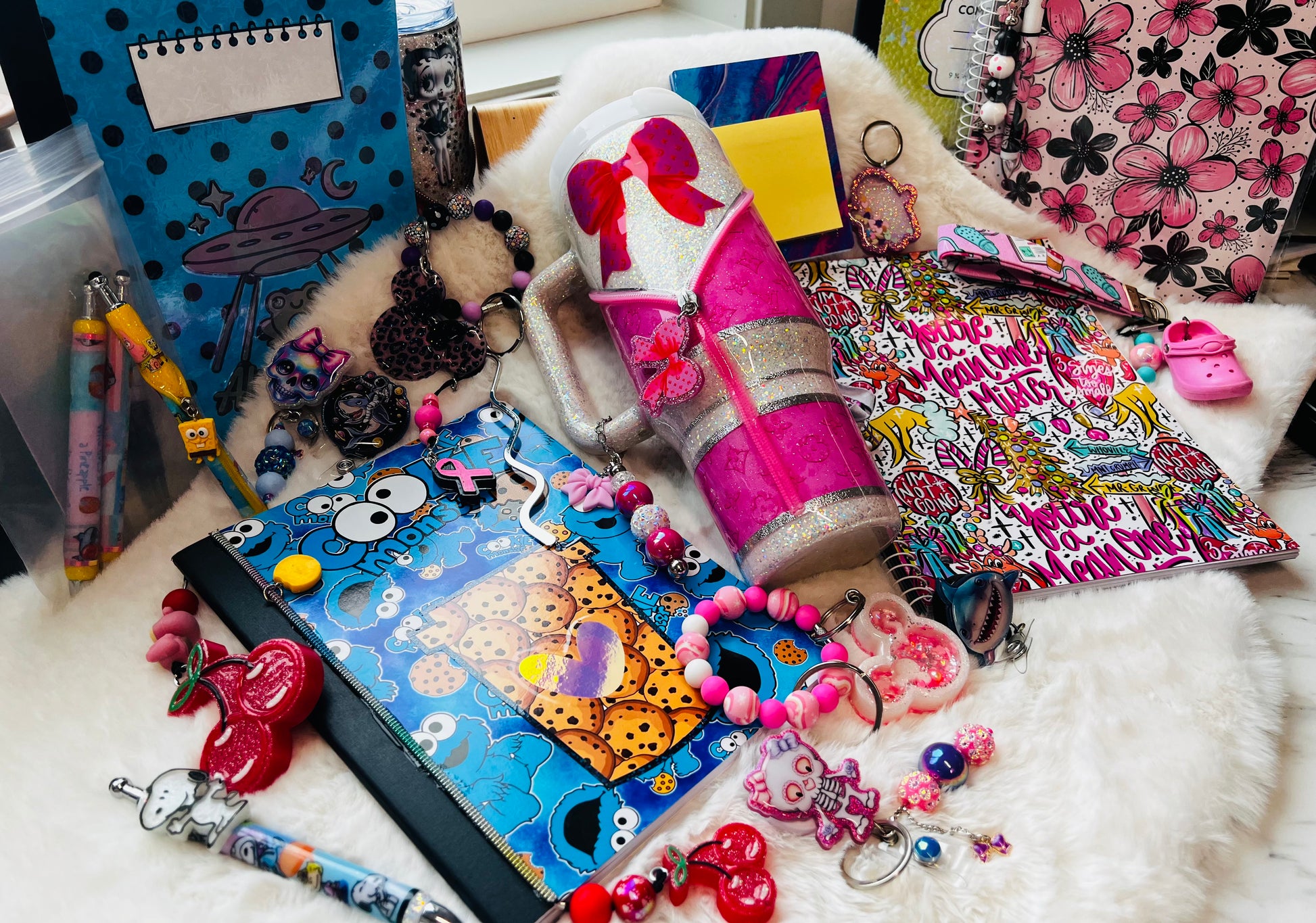 Colorful stationery items including notebooks, pens, and keychains on a white surface.