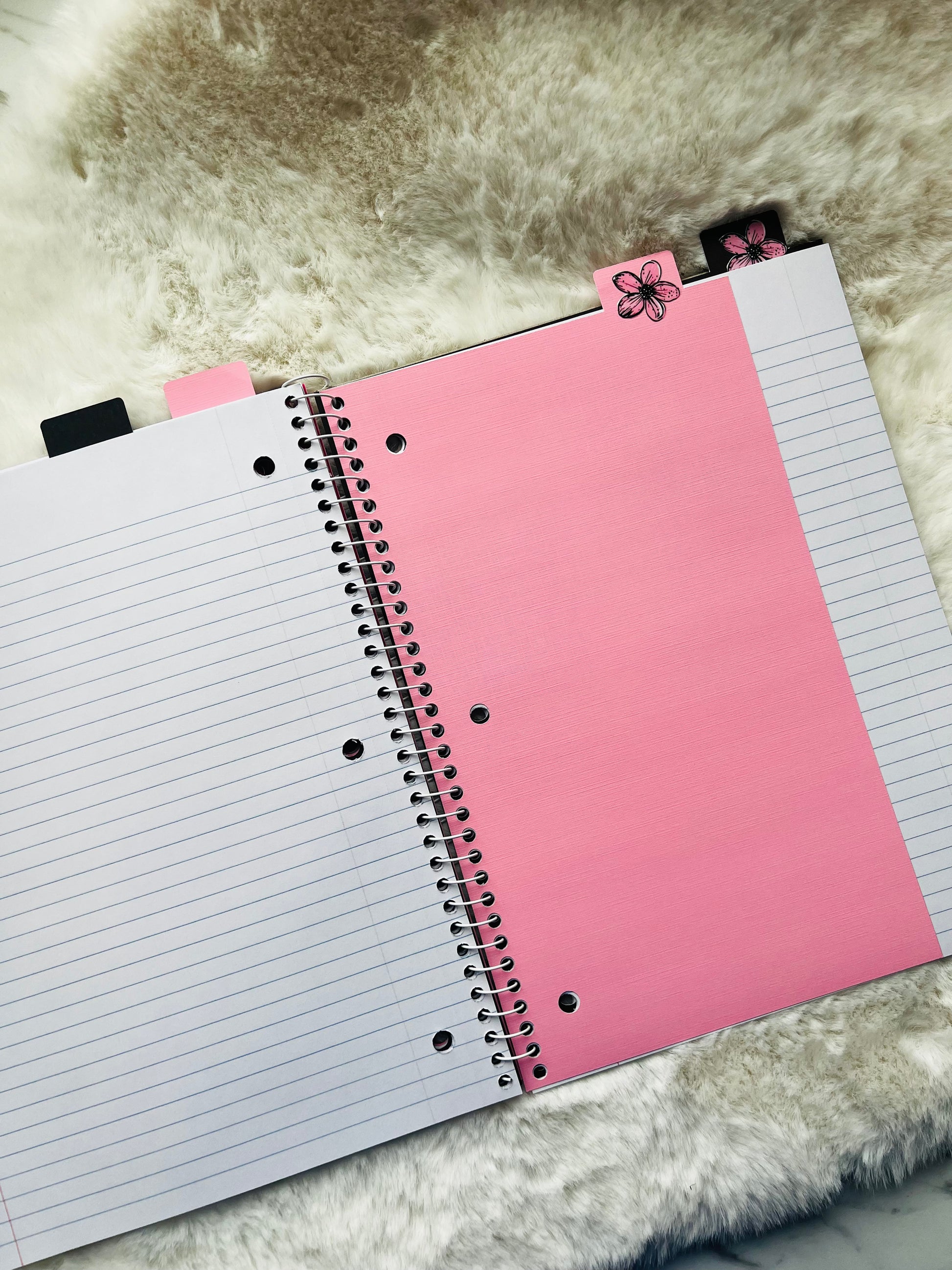 Notebook with pink and white pages on a textured surface
