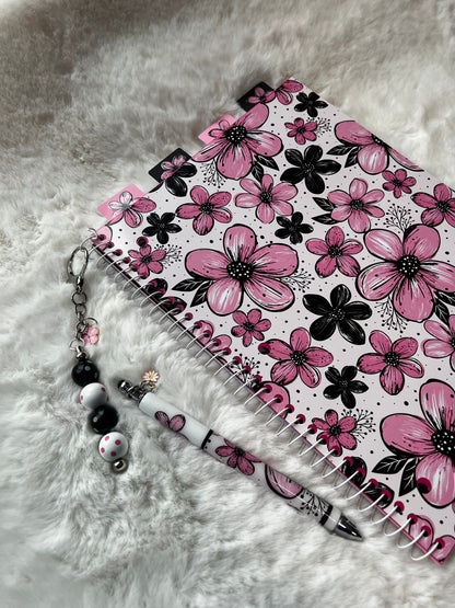 Notebook with pink floral design on a fluffy white surface