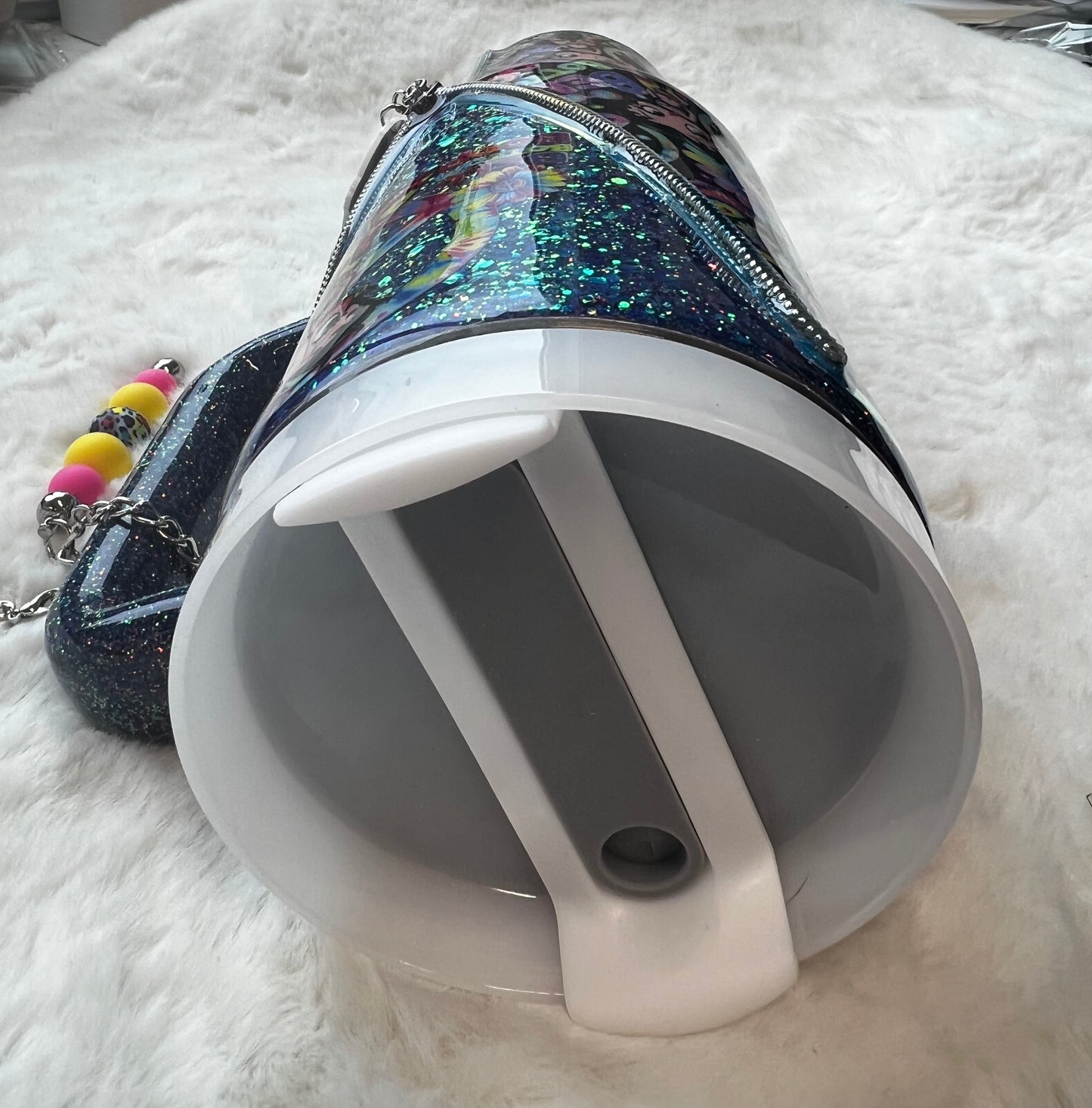 Colorful glittery tumbler with Betty Boop character design on a white fluffy surface