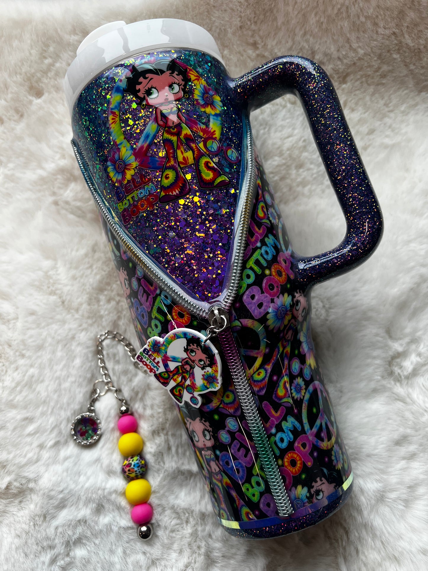 Colorful glittery tumbler with Betty Boop character design on a white fluffy surface