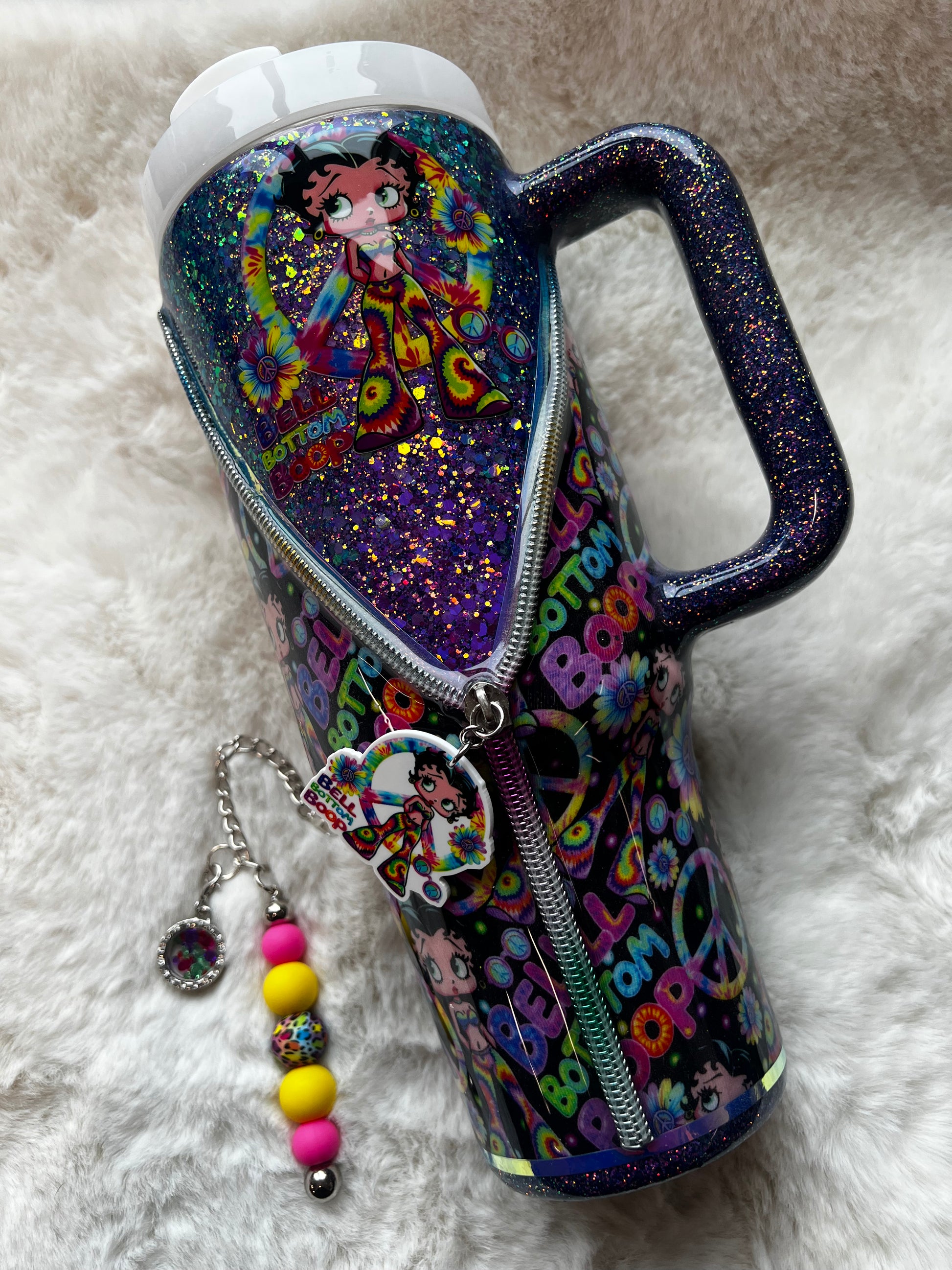 Colorful glittery tumbler with Betty Boop character design on a white fluffy surface