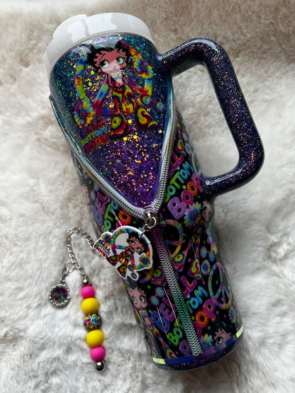 Colorful glittery tumbler with Betty Boop character design on a white fluffy surface