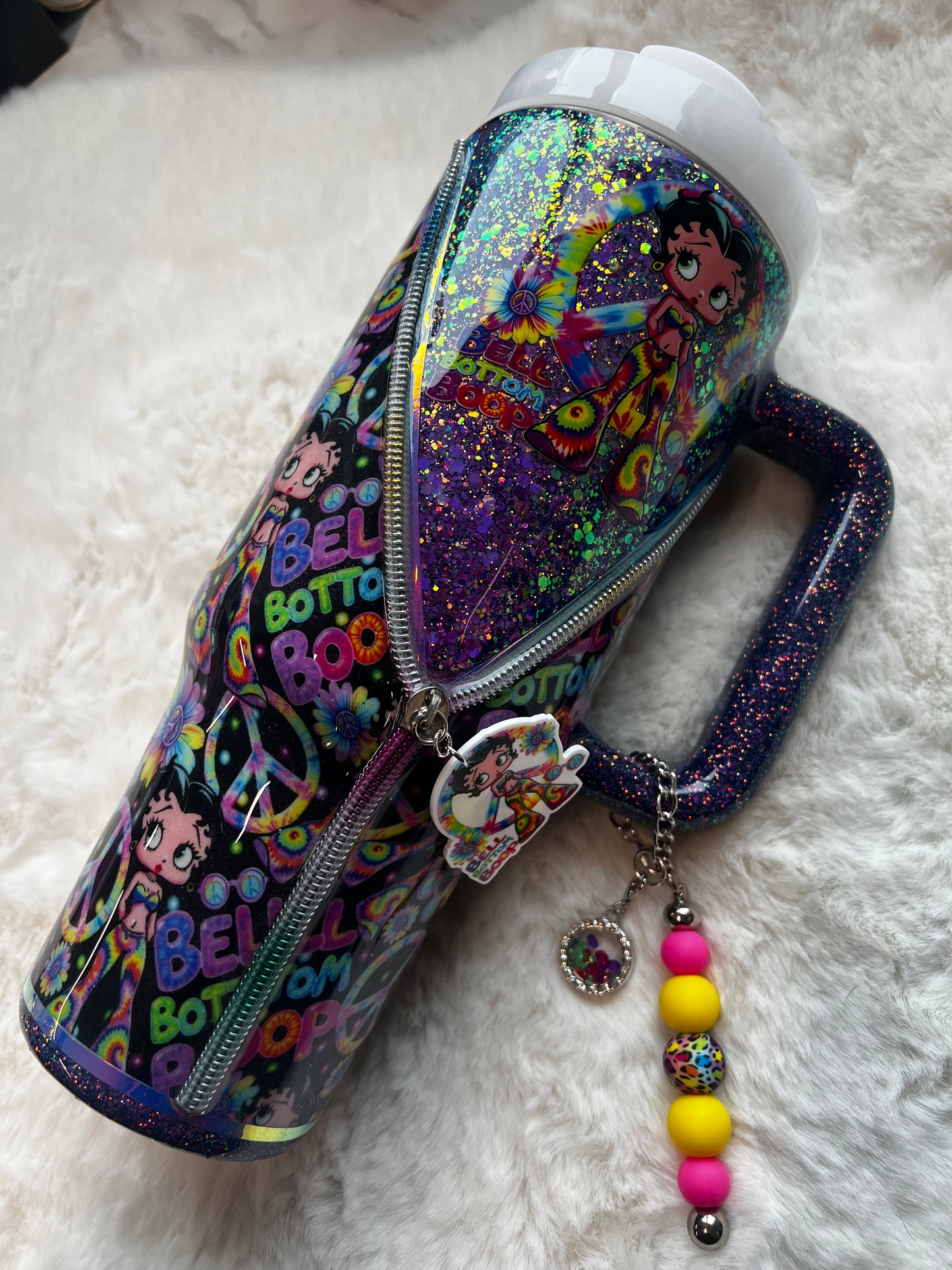 Colorful glittery tumbler with Betty Boop character design on a white fluffy surface