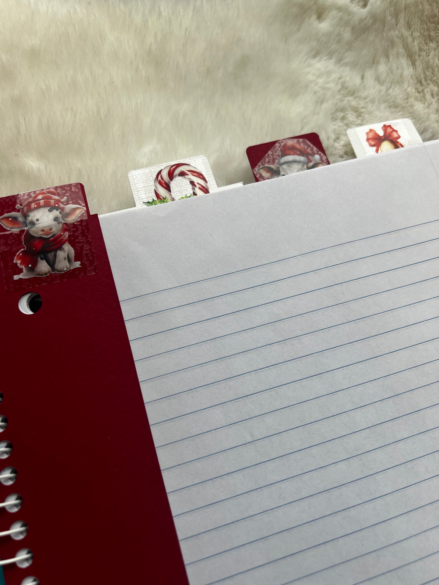 Notebook with lined pages and decorative tabs on a textured surface