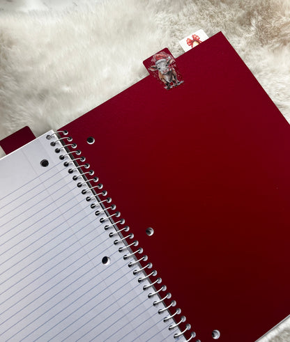 Red notebook with a white lined page on a textured surface