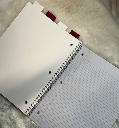 Notebook with spiral binding and lined pages on a textured surface