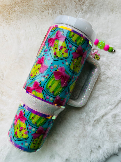 Colorful stainless steel tumbler with a pickle design and 'Pickle' text on a textured surface.