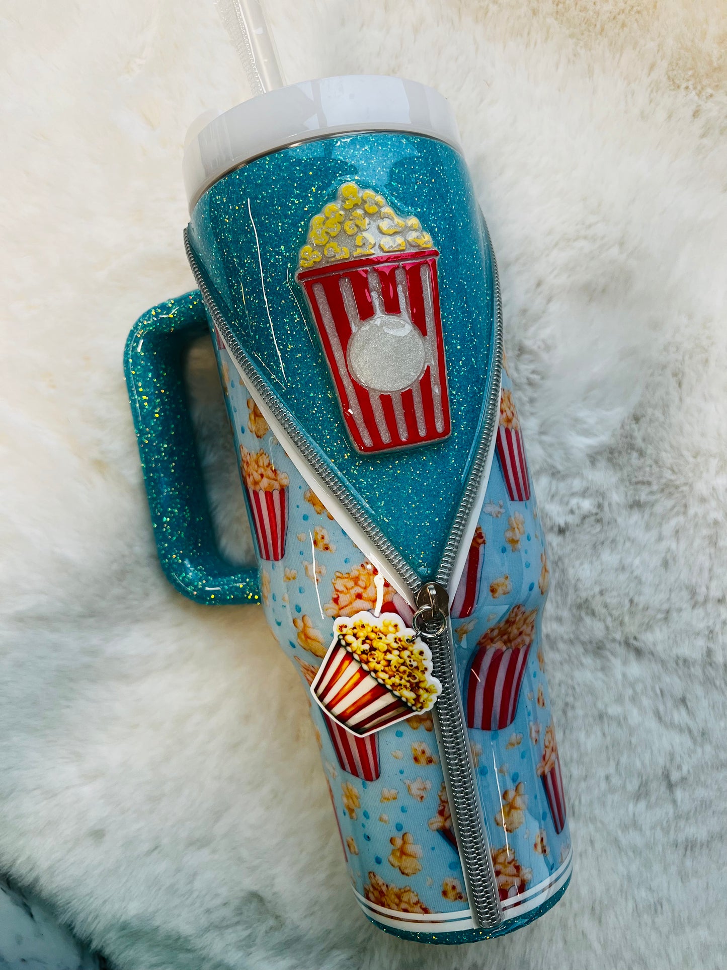 Tumbler with popcorn design on a fluffy white surface