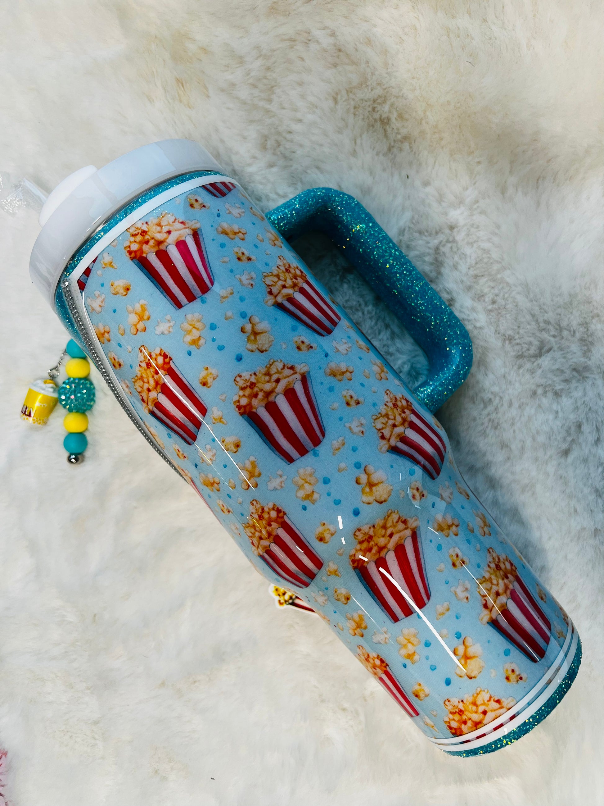 Tumbler with popcorn design on a fluffy white surface