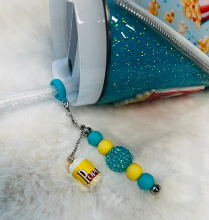 Colorful beaded keychain attached to a blue glittery tumbler on a white surface